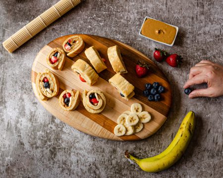 a wooden board of assorted fruit and pastries