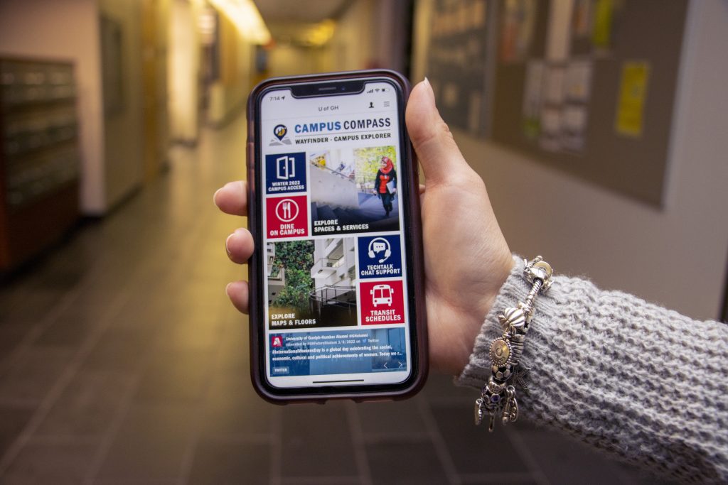 a person's hand holding their phone out with humber college app