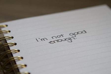 "I'm not good enough." written on notebook